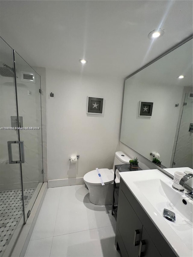 bathroom with tile patterned flooring, vanity, toilet, and an enclosed shower