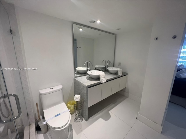 bathroom featuring tile patterned flooring, vanity, an enclosed shower, and toilet