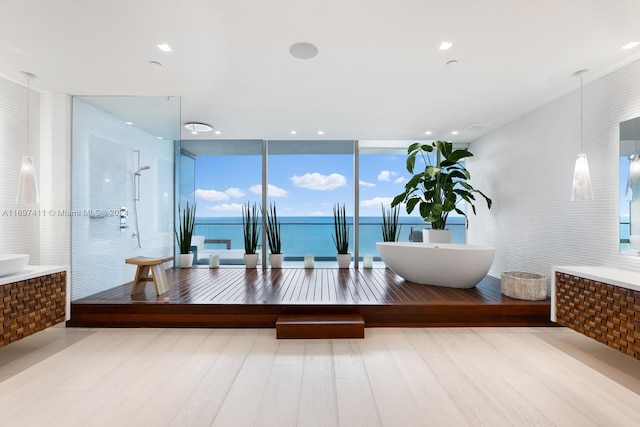 bathroom featuring floor to ceiling windows, a water view, and wood-type flooring