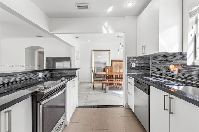 kitchen featuring tasteful backsplash, dishwasher, white cabinets, and a healthy amount of sunlight