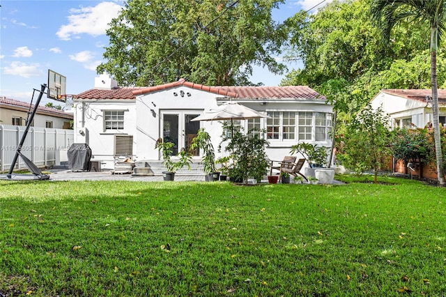 back of property with a yard and french doors