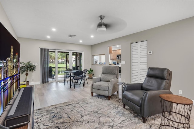 living area with ceiling fan and light hardwood / wood-style floors