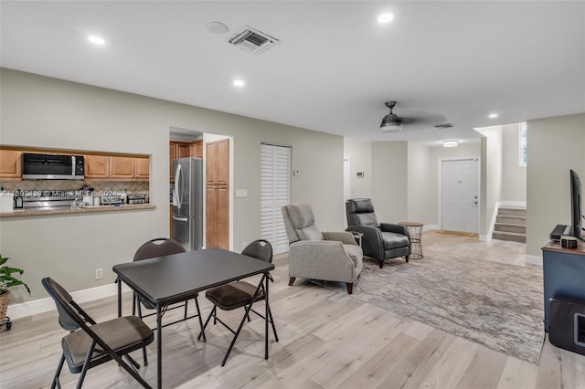 dining space featuring ceiling fan and light wood-type flooring