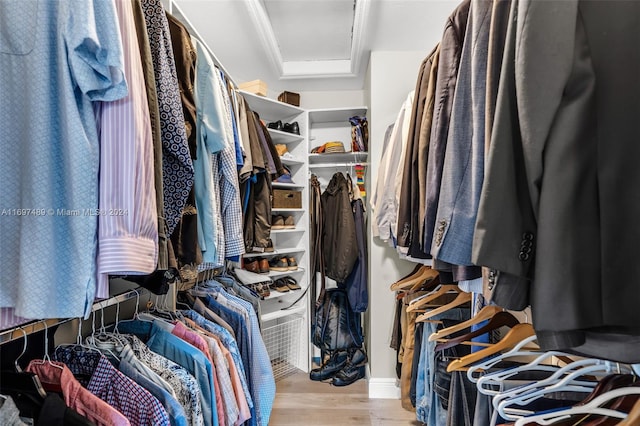 walk in closet with light hardwood / wood-style floors