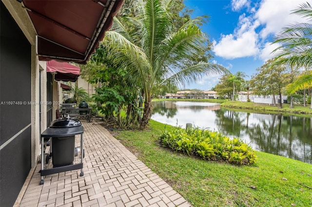 view of patio featuring a water view and a grill