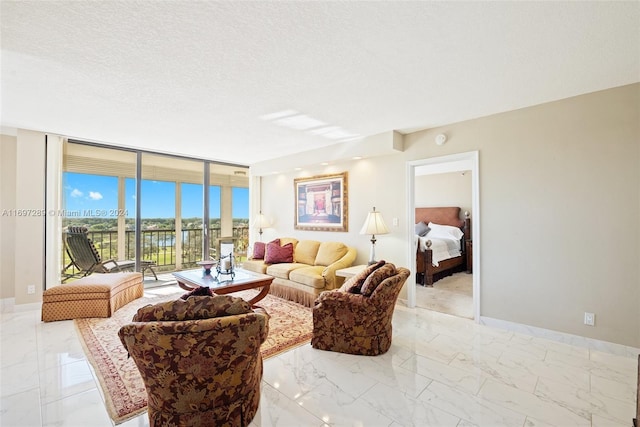 living room with a textured ceiling and a wall of windows