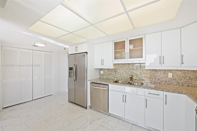 kitchen featuring backsplash, white cabinetry, sink, and stainless steel appliances