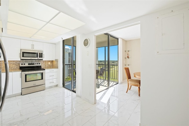 kitchen featuring tasteful backsplash, light stone counters, electric panel, white cabinets, and appliances with stainless steel finishes