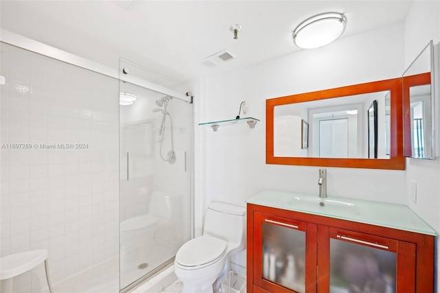 bathroom with an enclosed shower, vanity, and toilet