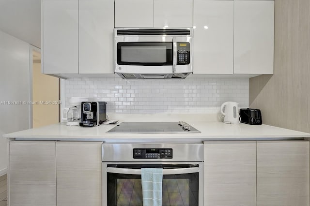 kitchen featuring white cabinets, backsplash, and stainless steel appliances