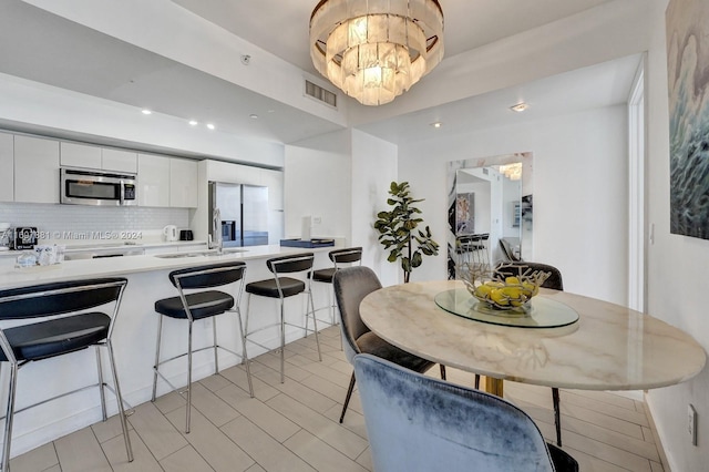 dining room with sink and an inviting chandelier