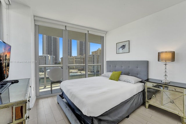 bedroom featuring expansive windows, access to exterior, and multiple windows