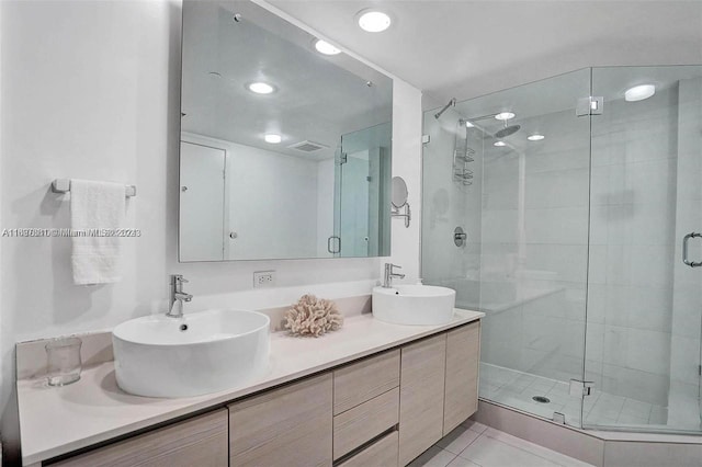 bathroom featuring tile patterned flooring, vanity, and a shower with door