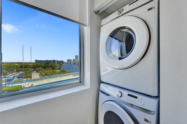 laundry area featuring a water view and stacked washer and clothes dryer