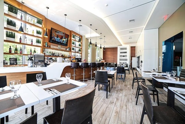 dining space featuring light hardwood / wood-style floors and bar