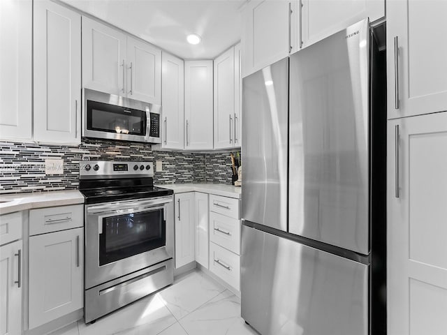 kitchen featuring white cabinets, decorative backsplash, and stainless steel appliances