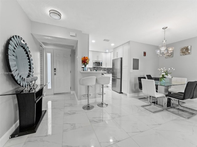 foyer entrance featuring visible vents, marble finish floor, baseboards, recessed lighting, and a chandelier