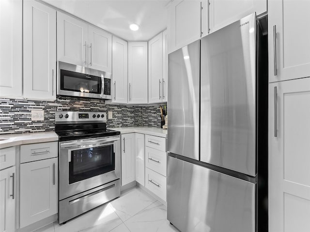 kitchen with light countertops, white cabinets, appliances with stainless steel finishes, and decorative backsplash
