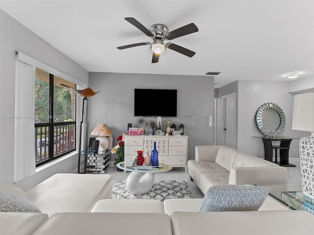 living area featuring a ceiling fan, baseboards, and visible vents