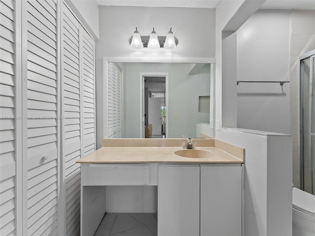 full bath featuring a closet, vanity, marble finish floor, toilet, and a shower stall