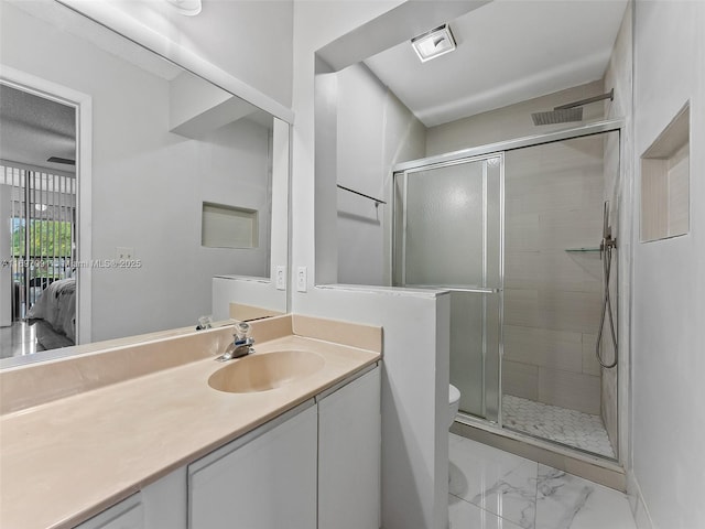 ensuite bathroom with a stall shower, vanity, toilet, marble finish floor, and ensuite bath