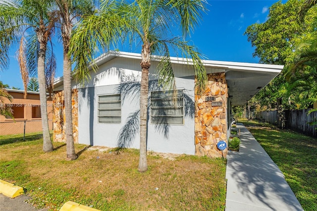 view of home's exterior with a yard and a carport