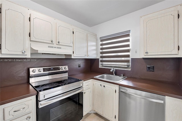 kitchen featuring light tile patterned floors, stainless steel appliances, tasteful backsplash, and sink