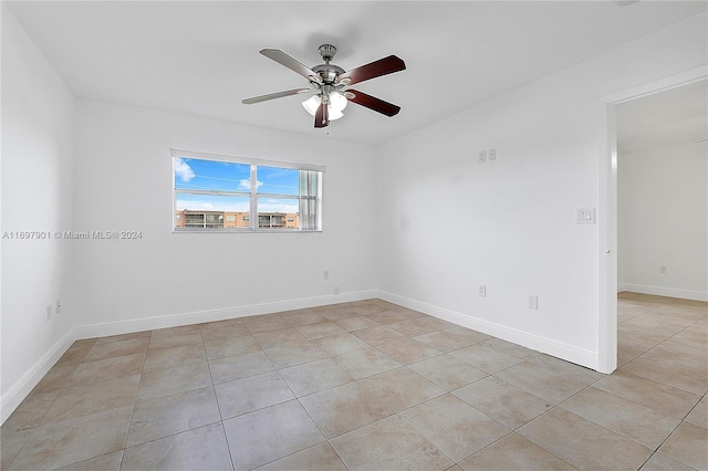 spare room featuring ceiling fan and light tile patterned floors