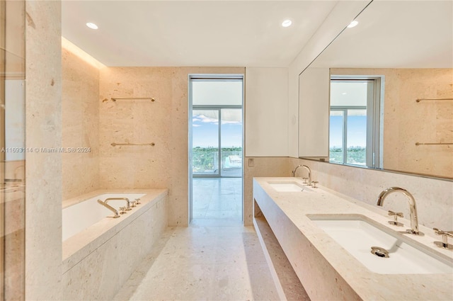 bathroom featuring vanity and a relaxing tiled tub