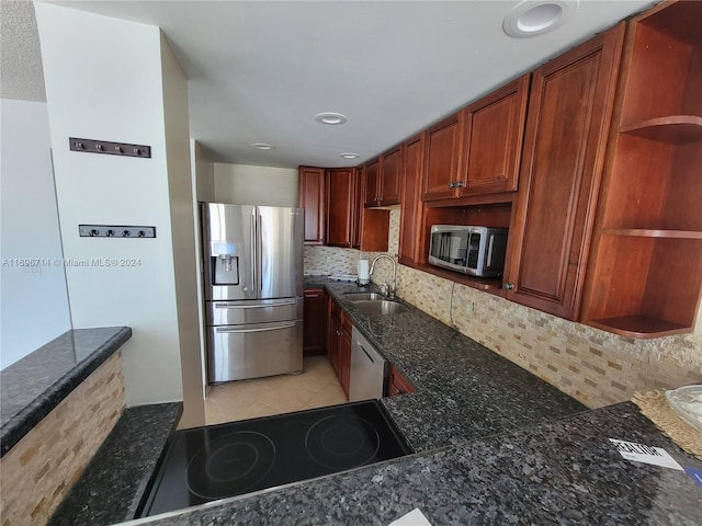 kitchen featuring a sink, open shelves, tasteful backsplash, stainless steel appliances, and dark stone counters