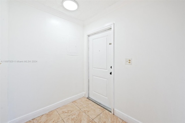 interior space featuring ornamental molding and light tile patterned flooring