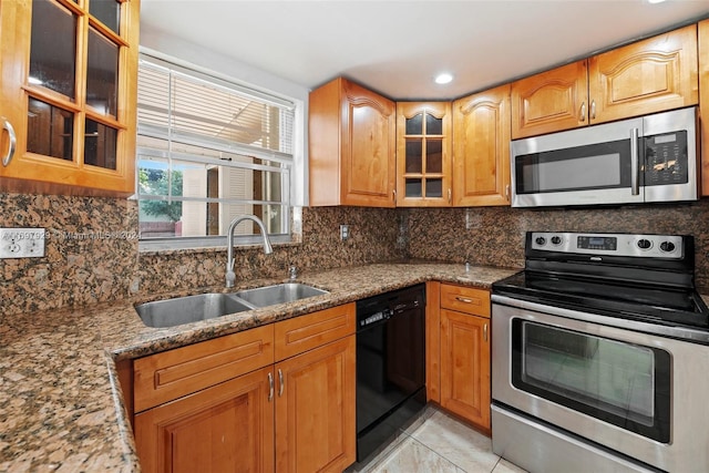 kitchen featuring sink, light tile patterned floors, stainless steel appliances, and stone counters