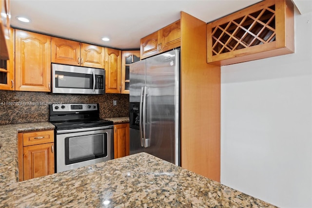 kitchen featuring appliances with stainless steel finishes, stone countertops, and tasteful backsplash