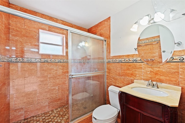 bathroom featuring vanity, toilet, tile walls, and walk in shower