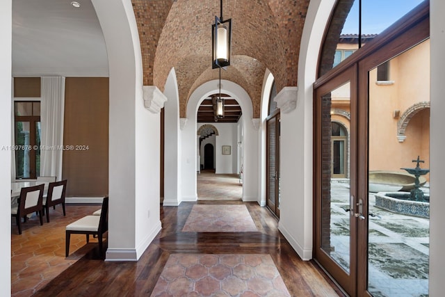 foyer with french doors, dark hardwood / wood-style flooring, and vaulted ceiling