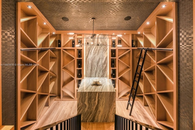 wine room featuring wood-type flooring and brick wall