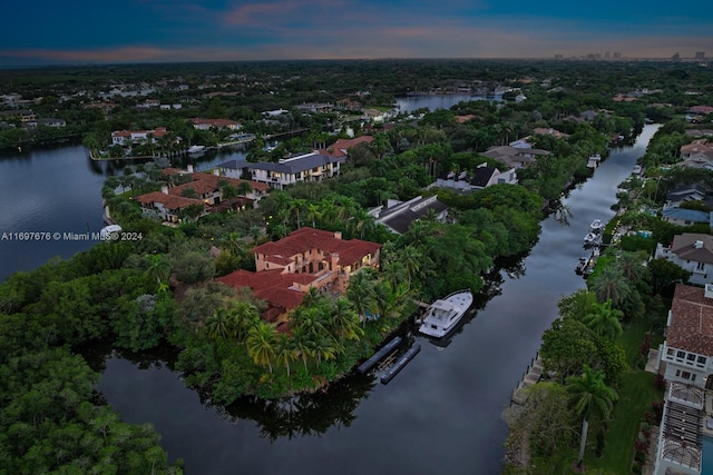 aerial view at dusk featuring a water view