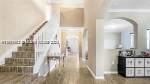 corridor with wood-type flooring and ornamental molding