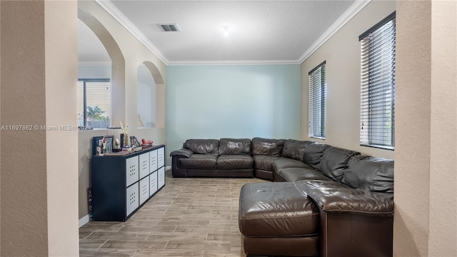 living room with a textured ceiling, light hardwood / wood-style floors, and ornamental molding