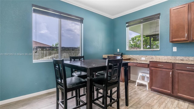 dining room featuring ornamental molding and light hardwood / wood-style flooring