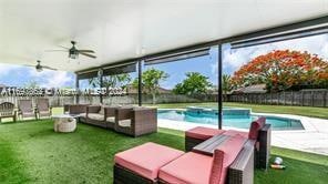 view of pool featuring a lawn, ceiling fan, and an outdoor hangout area