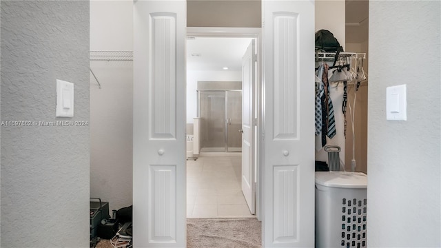 bathroom with tile patterned flooring and a shower with door