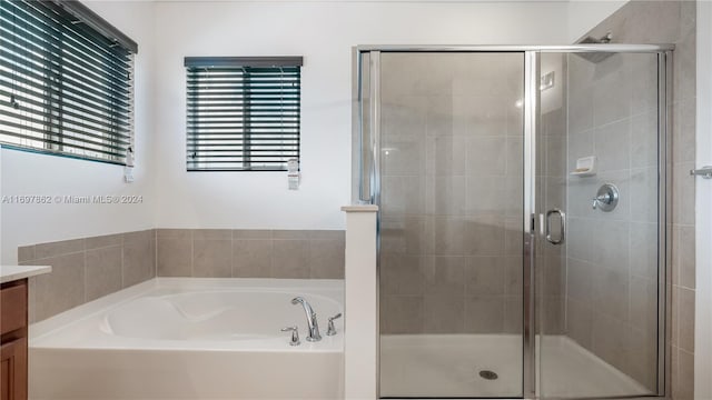 bathroom featuring vanity, a healthy amount of sunlight, and shower with separate bathtub