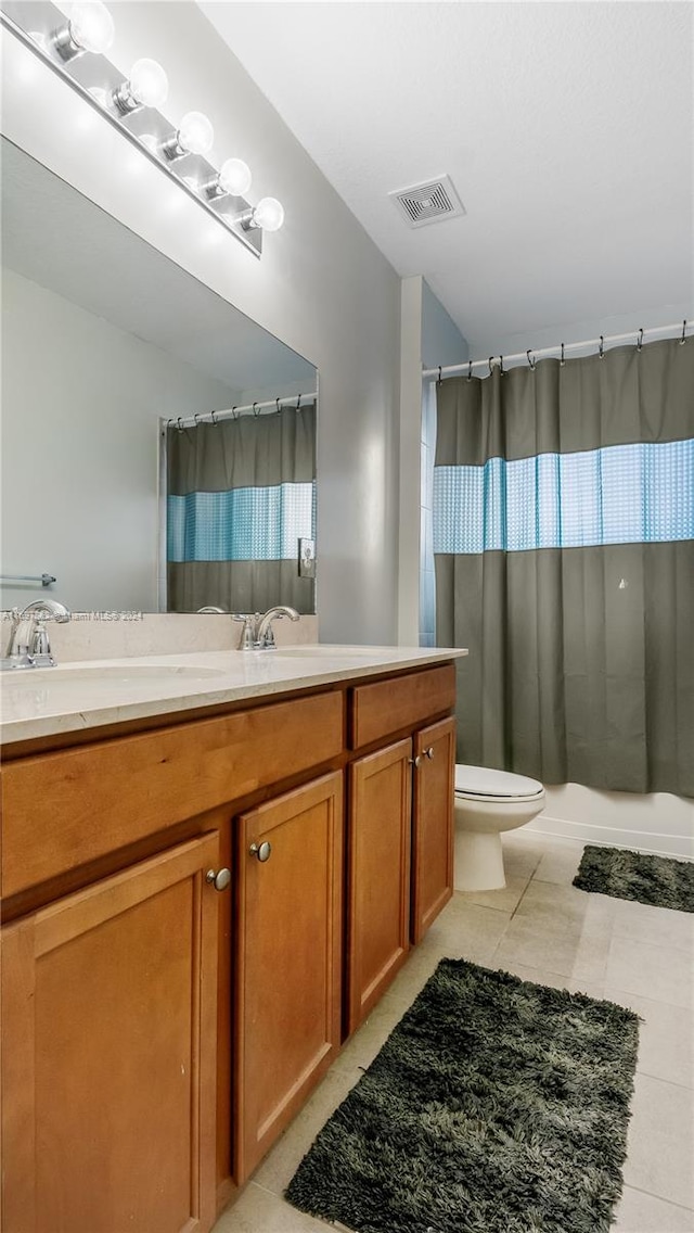 bathroom with tile patterned flooring, vanity, and toilet