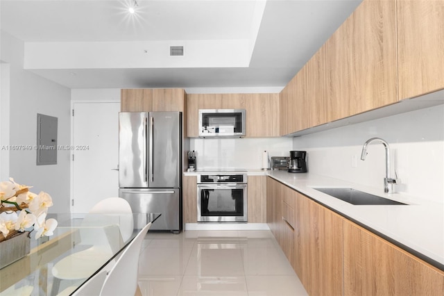 kitchen with sink, light brown cabinets, stainless steel appliances, electric panel, and light tile patterned floors