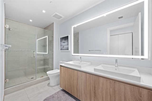 bathroom featuring tile patterned flooring, vanity, toilet, and an enclosed shower