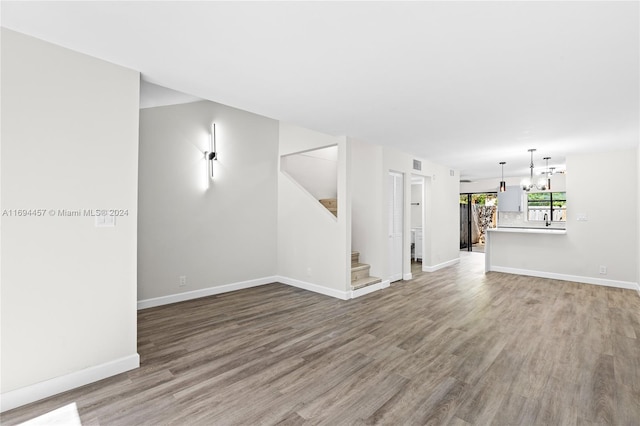 spare room with a chandelier and hardwood / wood-style floors