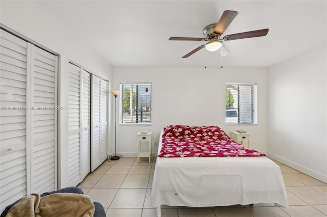 bedroom with multiple windows, ceiling fan, and light tile patterned floors