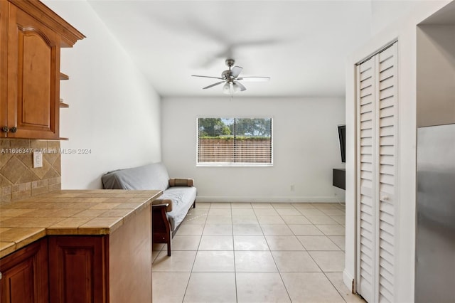 living area with ceiling fan and light tile patterned flooring