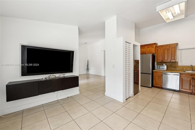 kitchen with decorative backsplash, light tile patterned floors, and appliances with stainless steel finishes